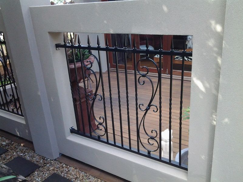 A white fence with a black wrought iron railing