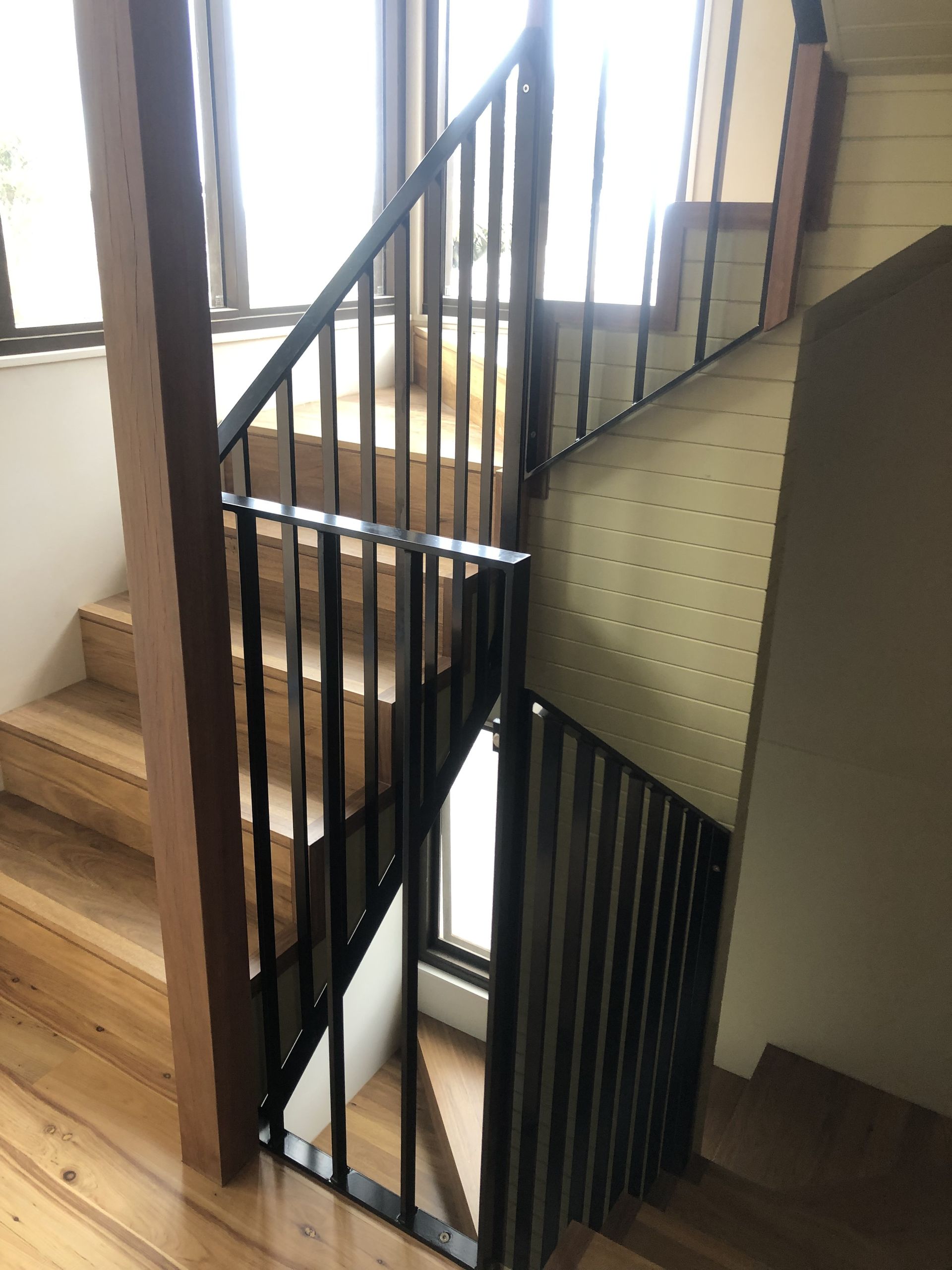 A staircase with a metal railing and wooden steps