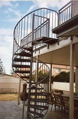 A spiral staircase leading up to a deck with a railing