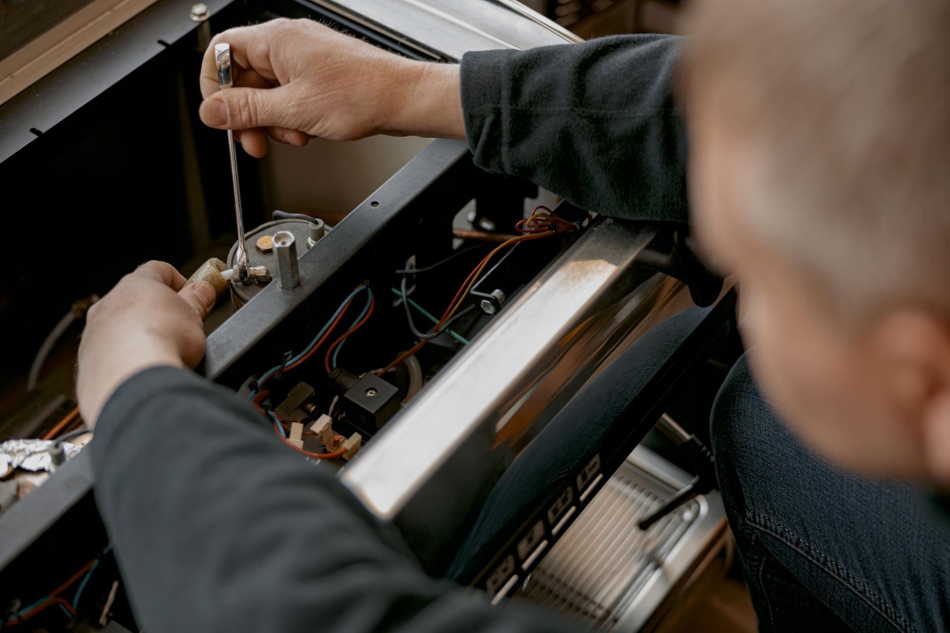 A Man is Working on a Machine With a Screwdriver — Labroco Gourmet Coffee Supplier In Forster, NSW