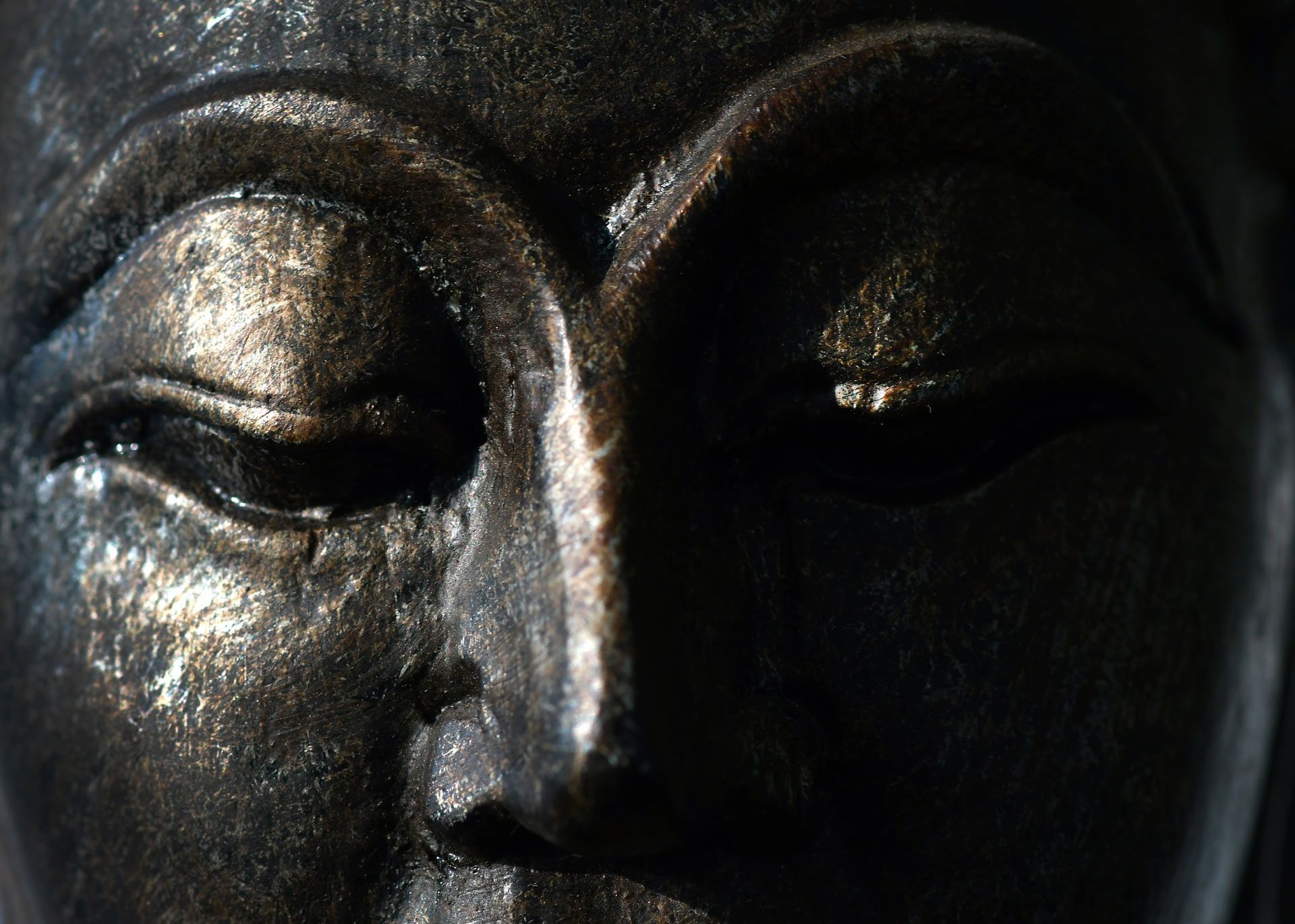 A close up of a statue of a Buddha's face
