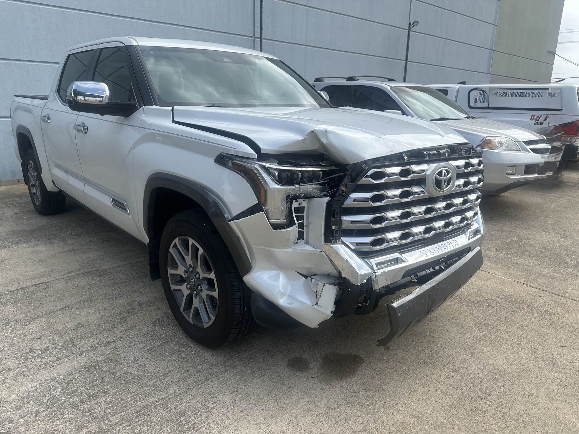 White SUV with severe front-end damage parked in a lot