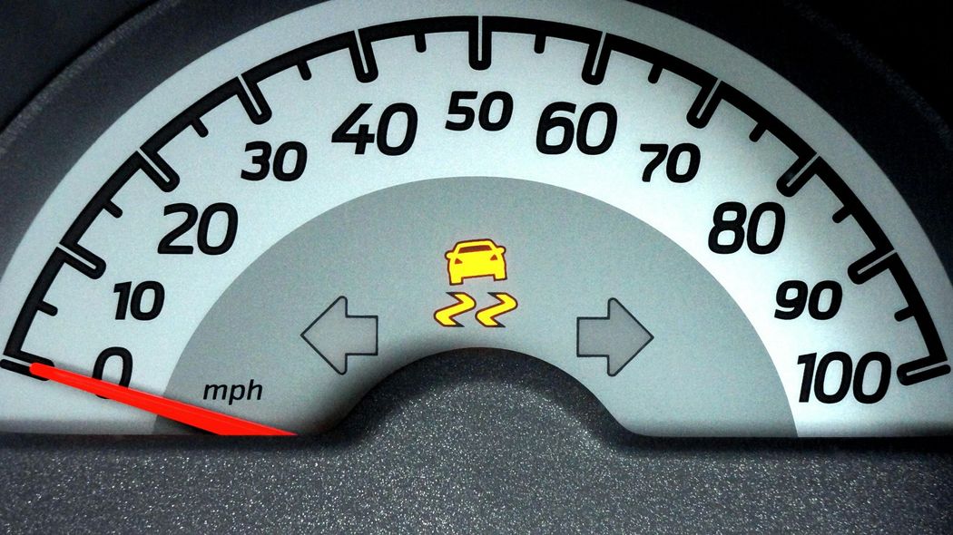 Dashboard speedometer with a lit traction control warning light.