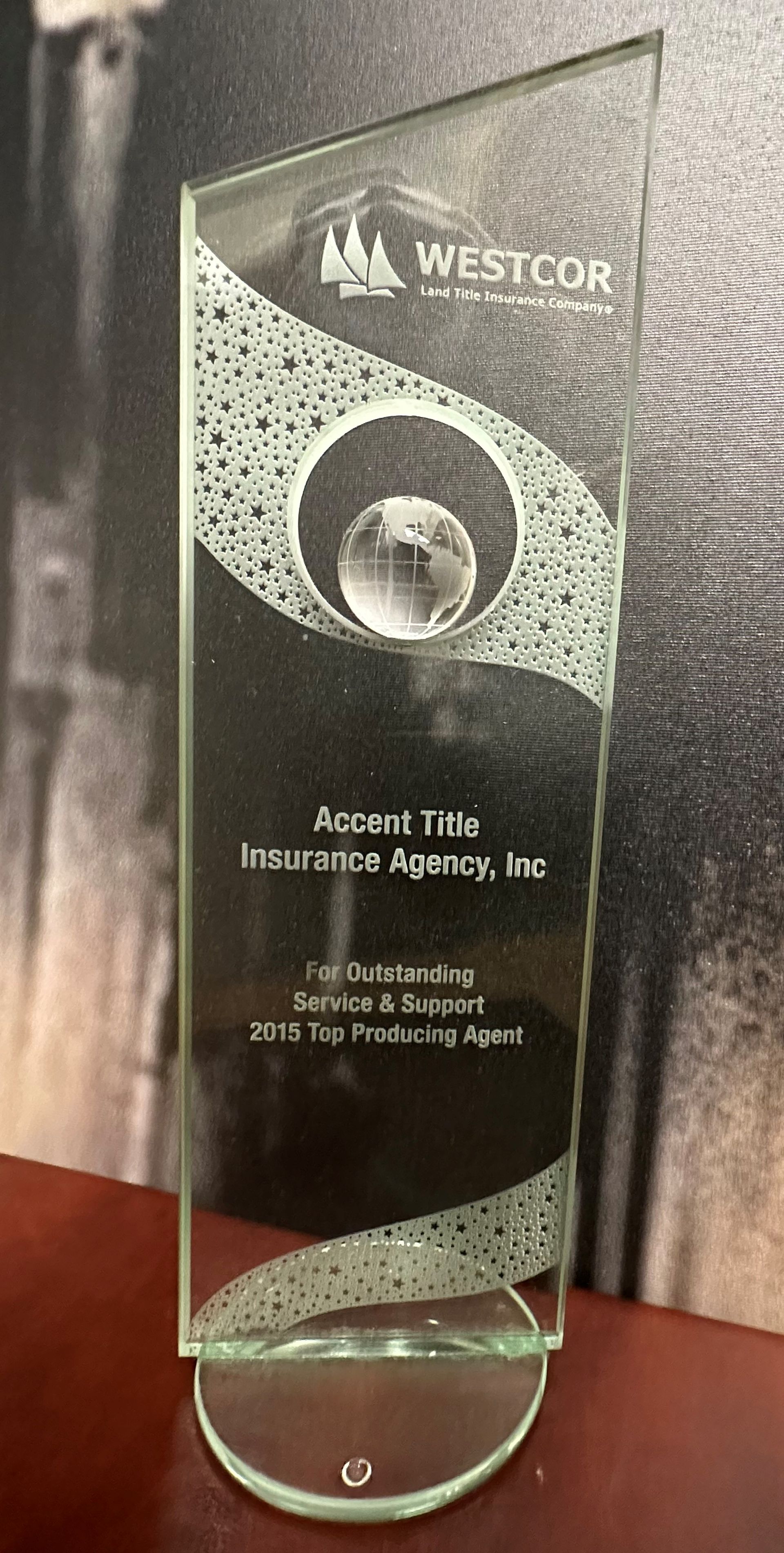 A glass trophy is sitting on top of a wooden table.