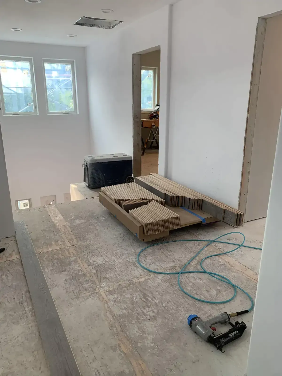 A room under construction with a stapler on the floor.