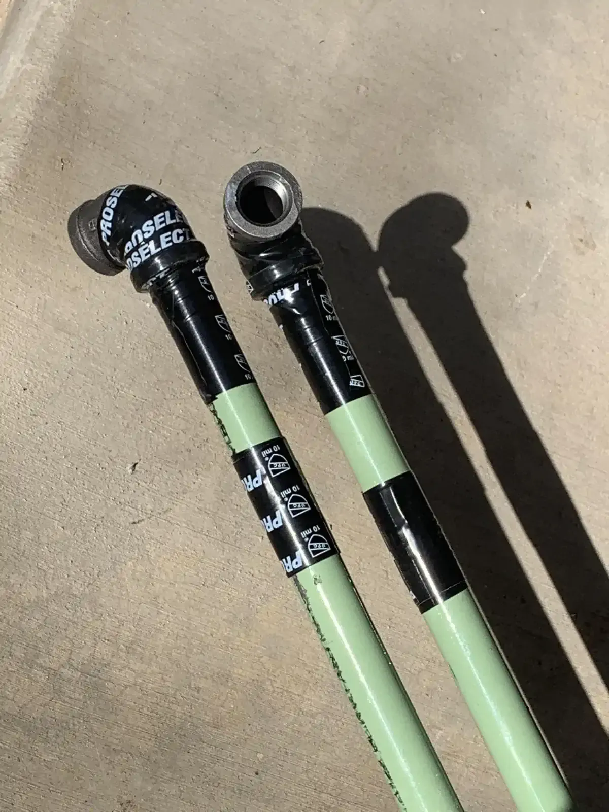 A pair of pipes are sitting next to each other on a concrete surface.