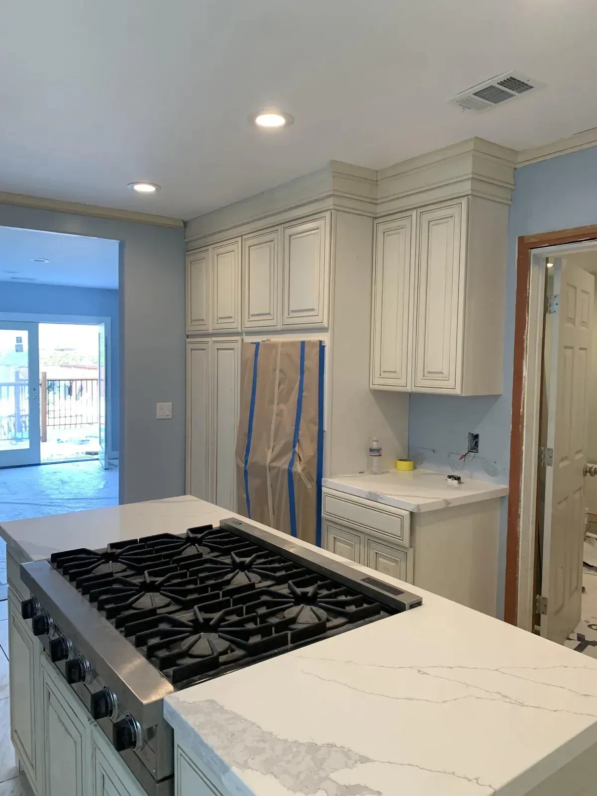 A kitchen with a large stove top oven and white cabinets.