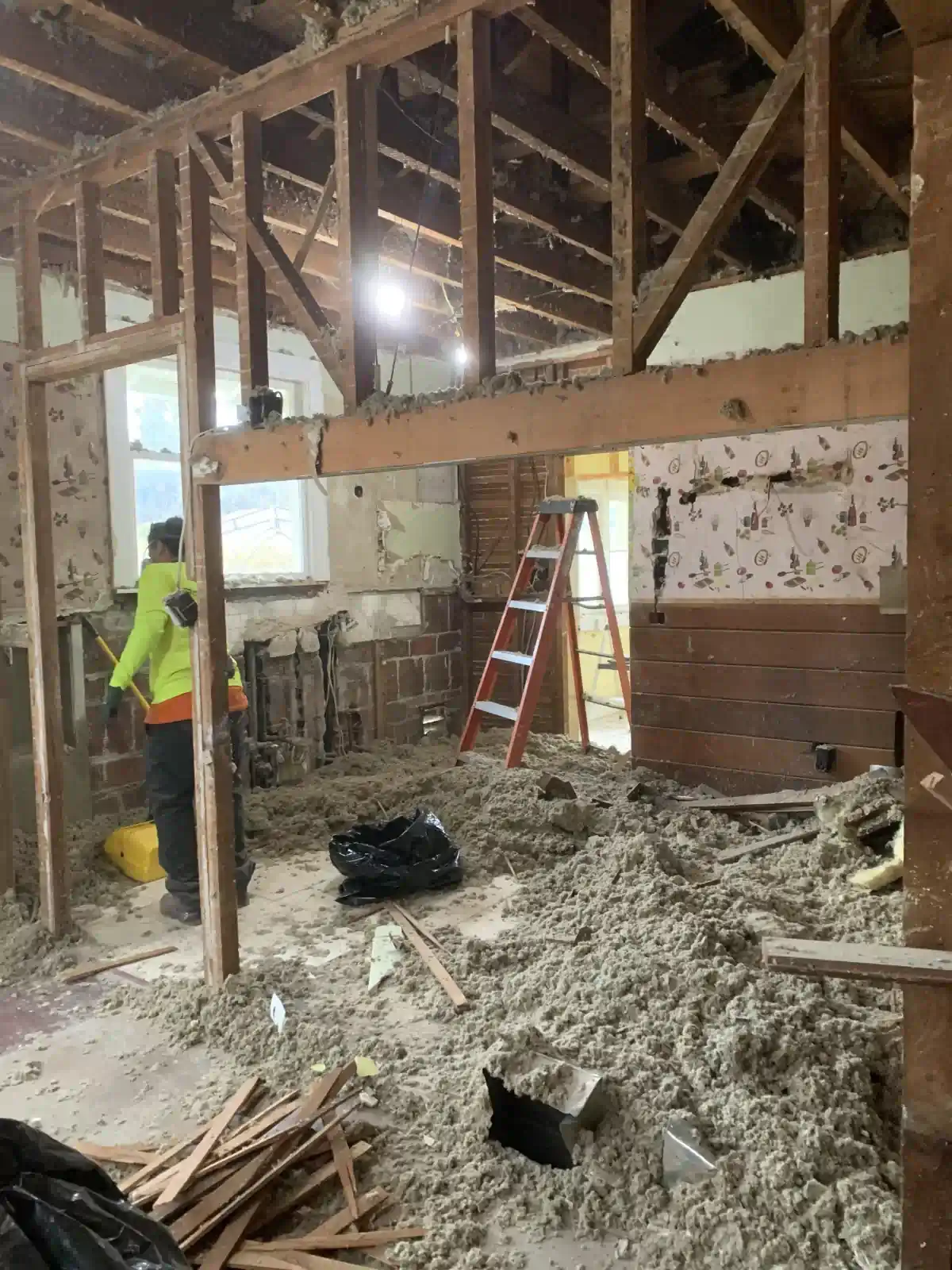 A man is standing in a room that is being remodeled.