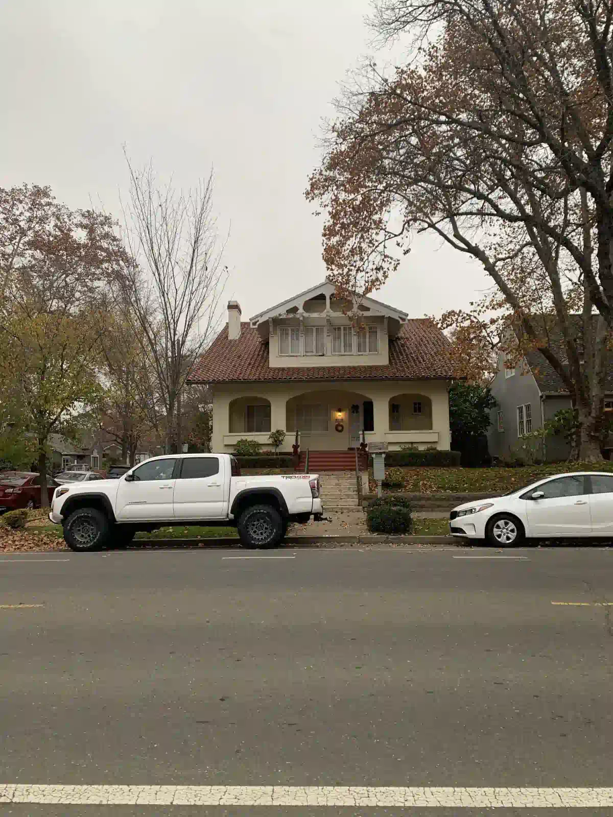 A white truck is parked in front of a house.