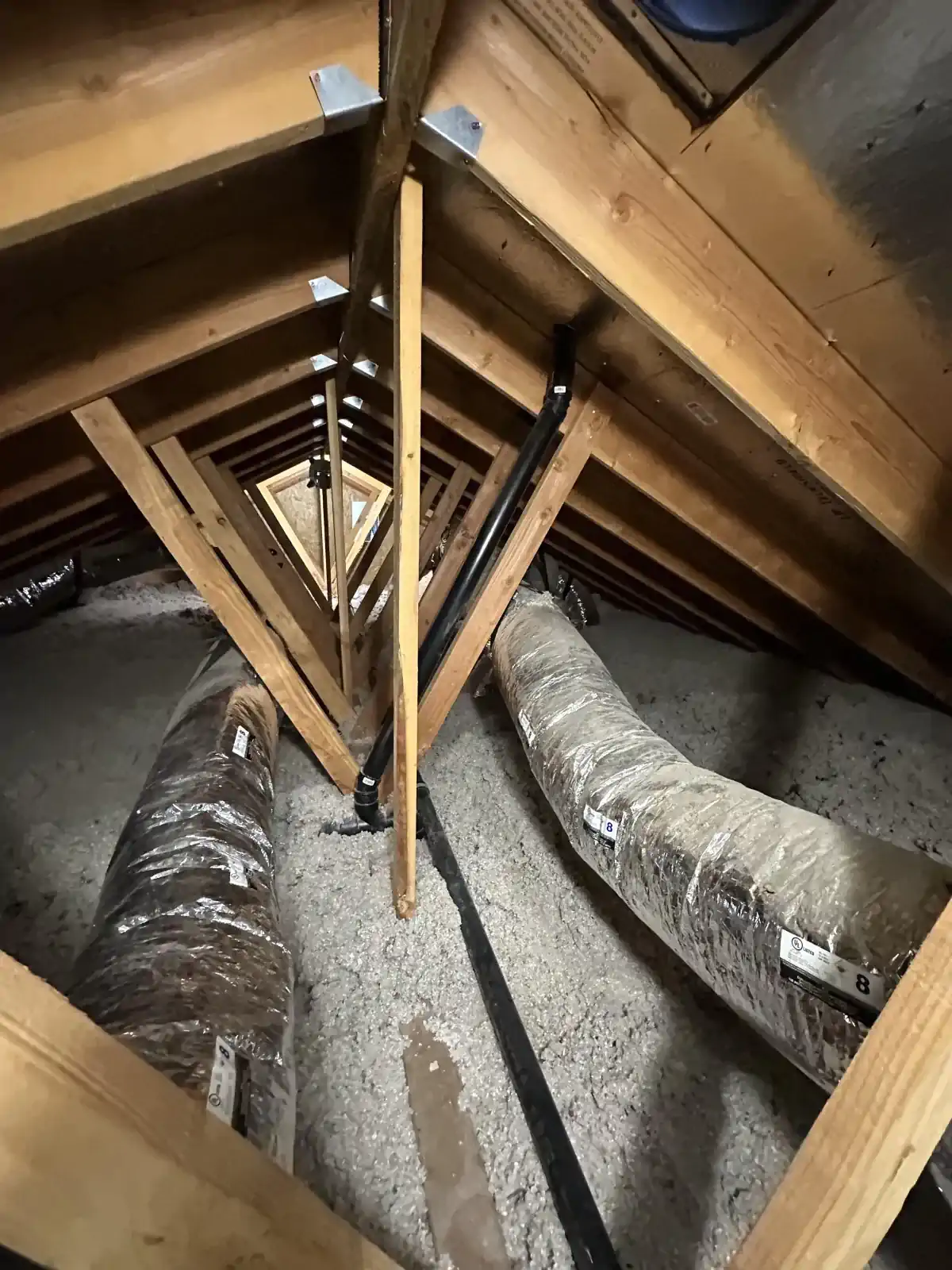 A room with a lot of wooden beams and pipes in it.