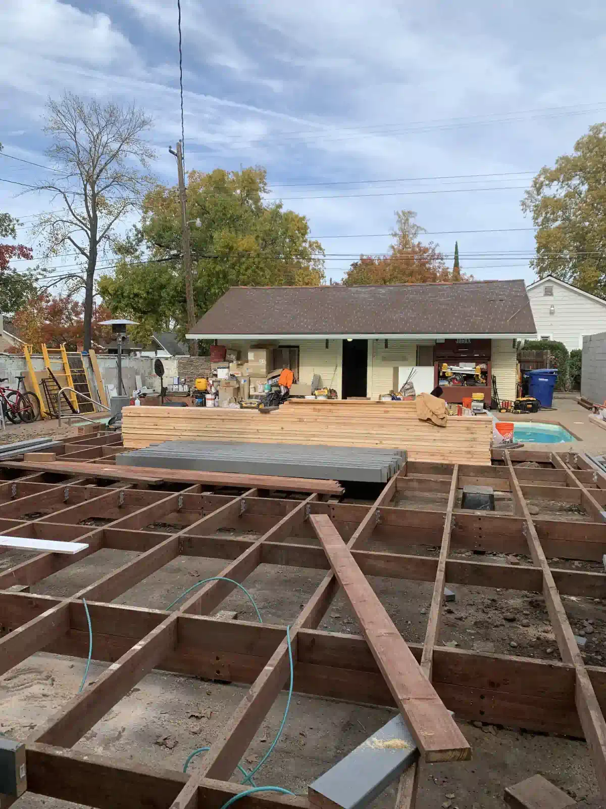 A wooden deck is being built in front of a house.