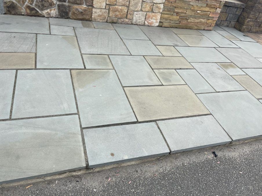 A stone walkway with a stone wall in the background