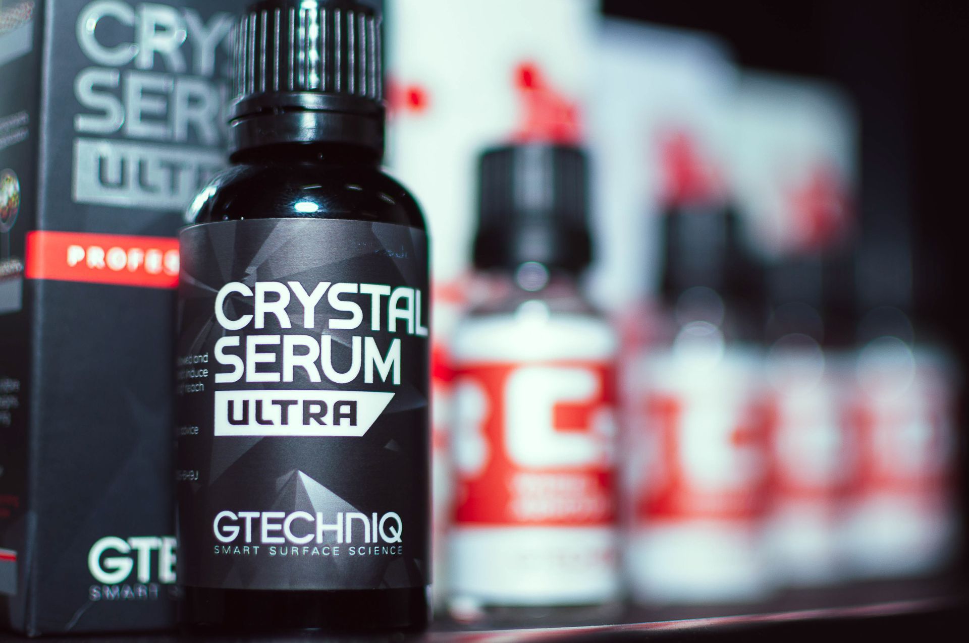 Black bottle labeled “Crystal Serum Ultra” on a blurred retail shelf with red-and-white bottles behind it