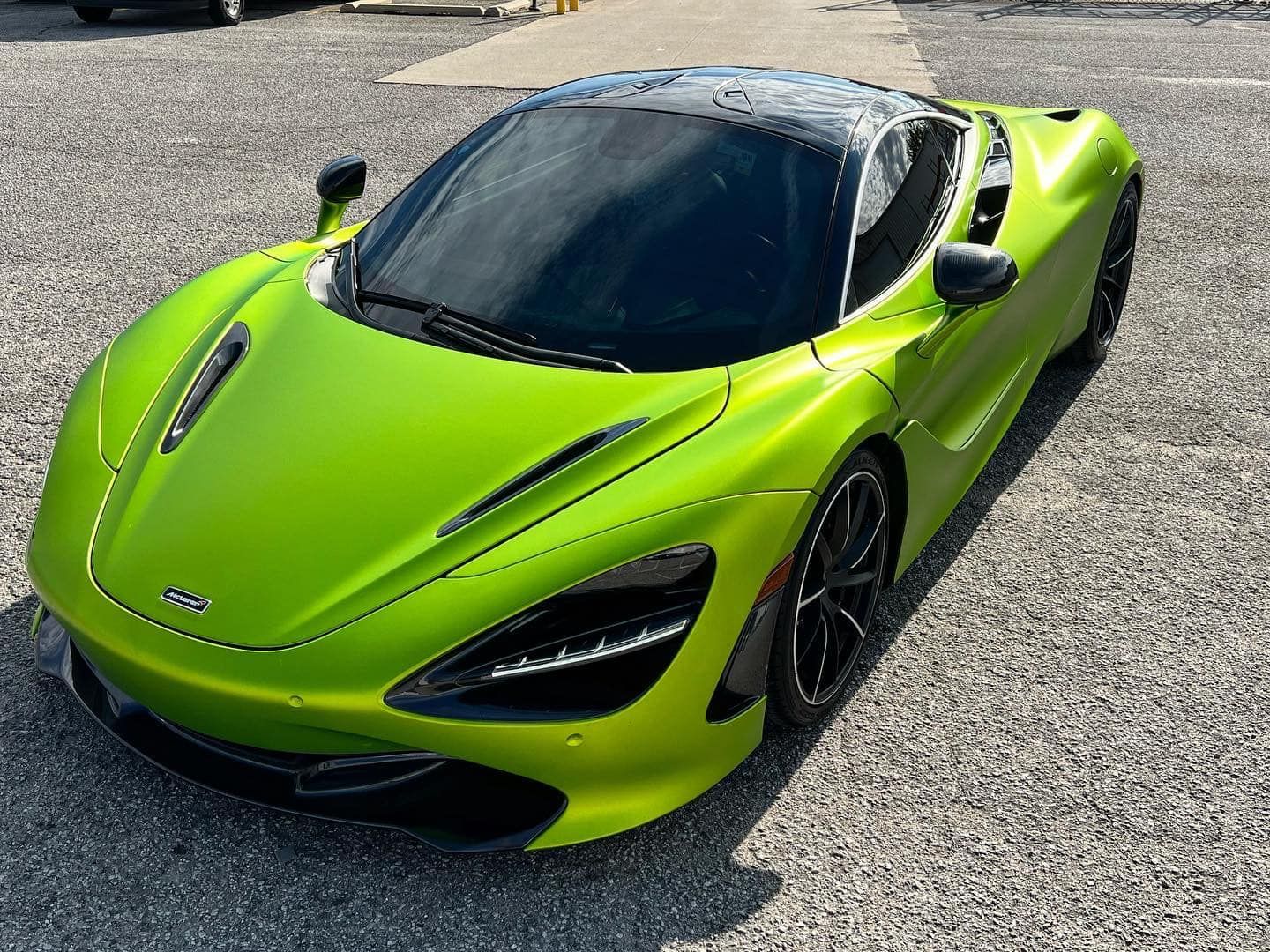 Bright lime green sports car parked on asphalt, viewed from above.