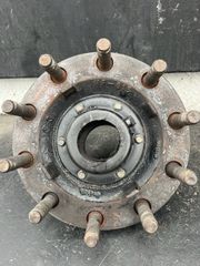 Rusty wheel hub with multiple lug studs and central bearing on a dark background