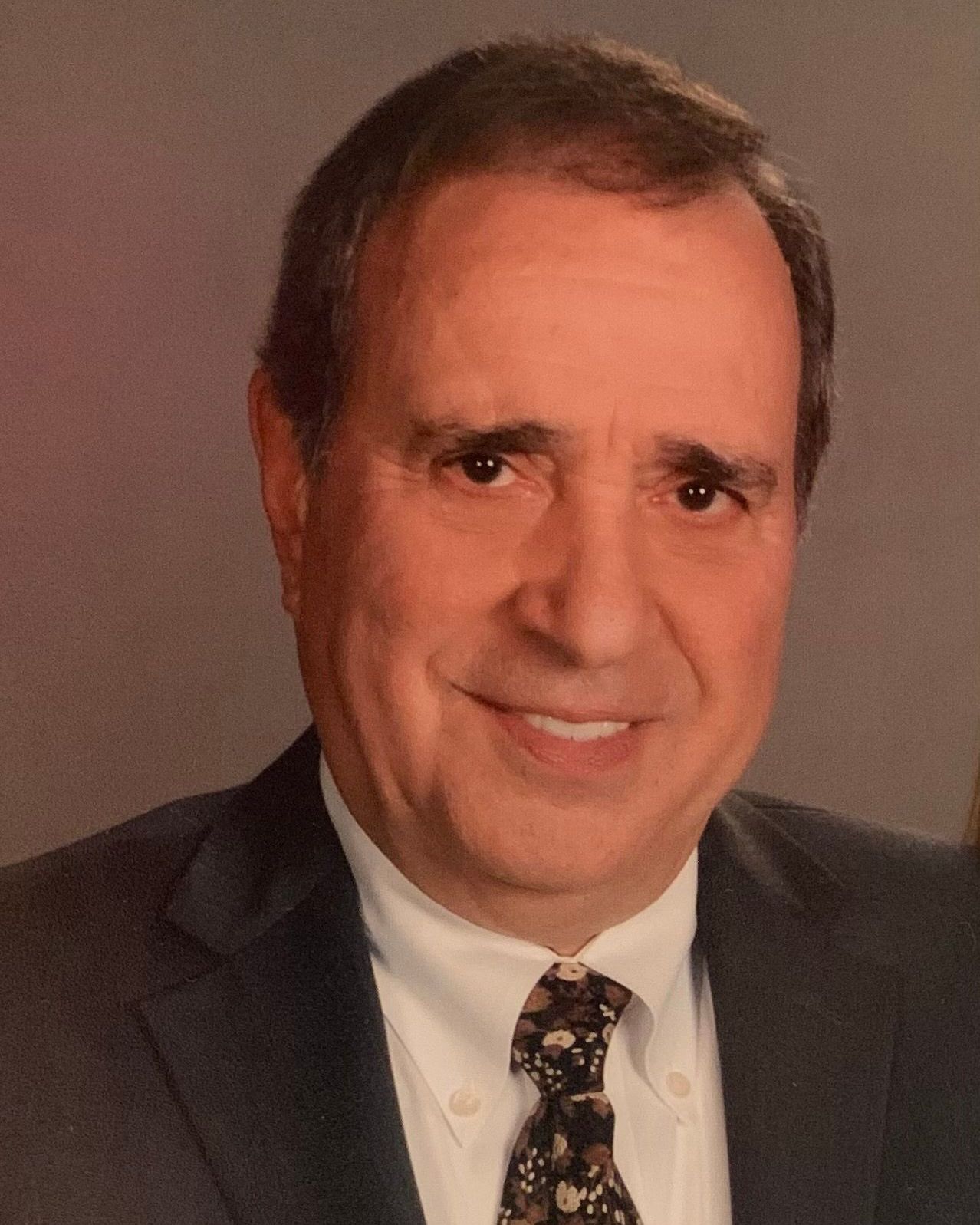 A man in a suit and tie is smiling for the camera.