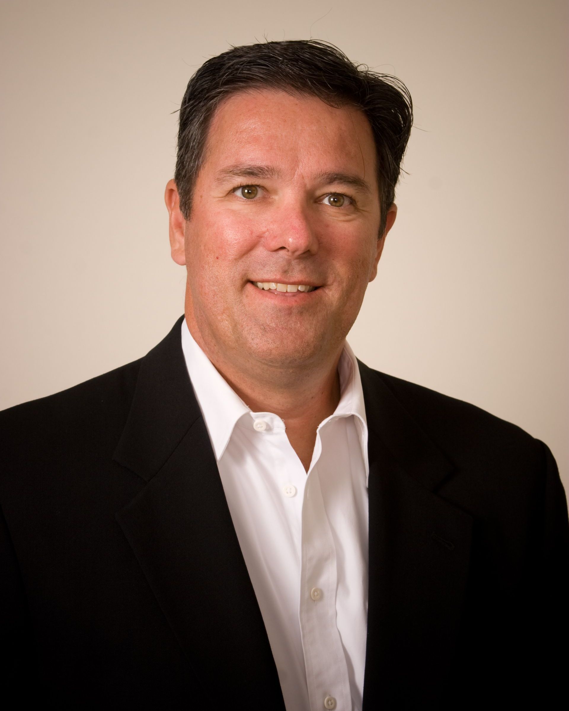 A man in a suit and tie is smiling for the camera.