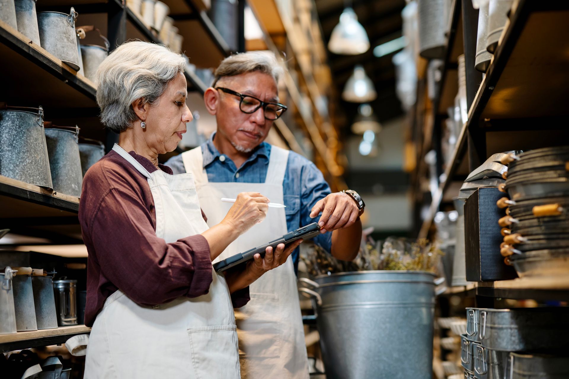 A man and a woman are working in a warehouse.