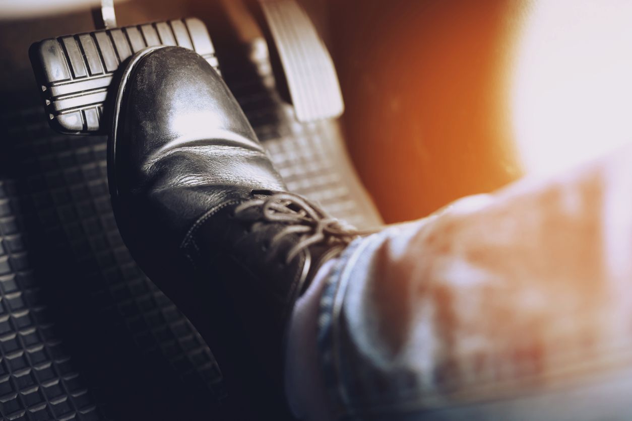 A person is pressing the brake pedal of a car.