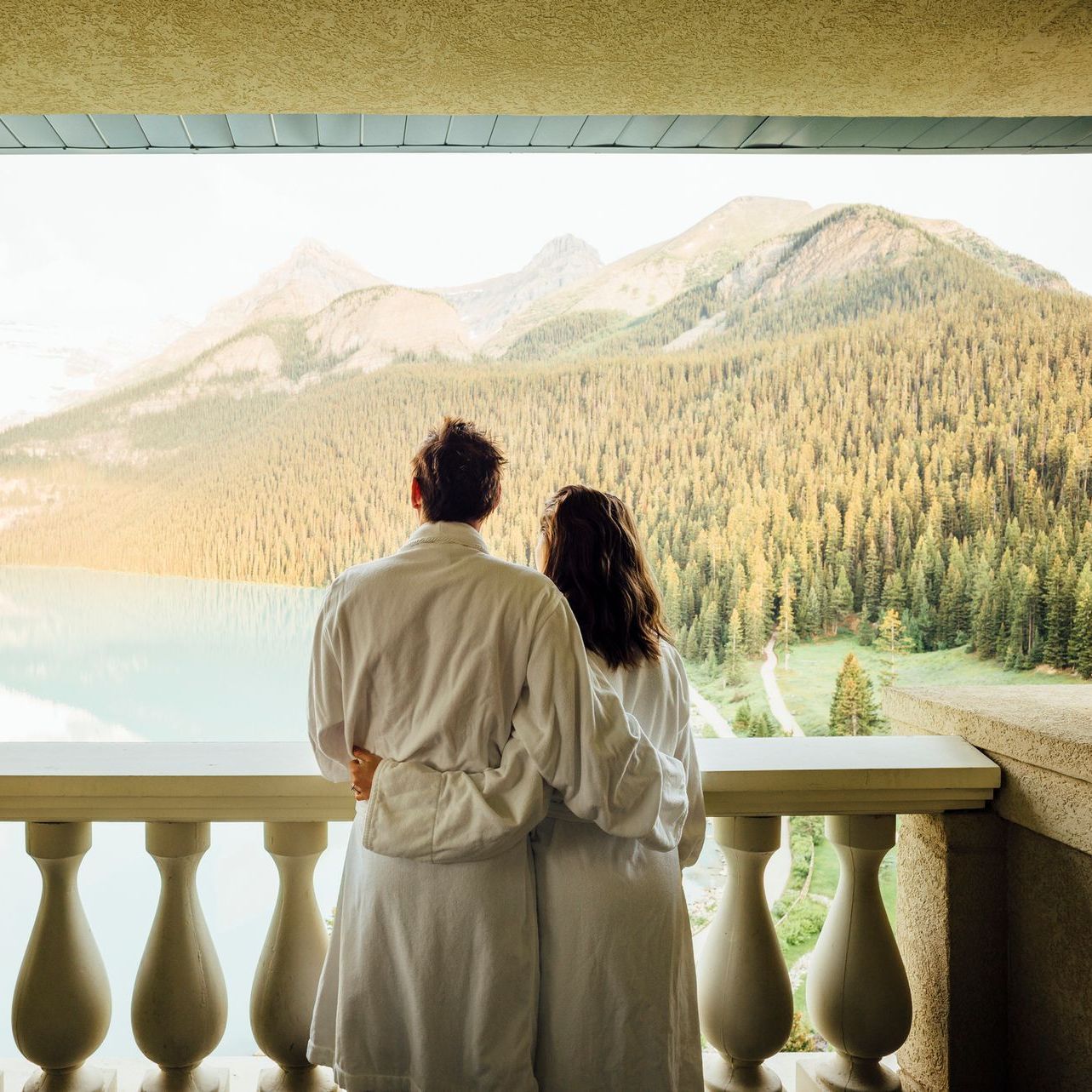 Un uomo e una donna sono in piedi su un balcone che guarda verso un lago