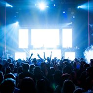 Una folla di persone a un concerto con le mani in aria