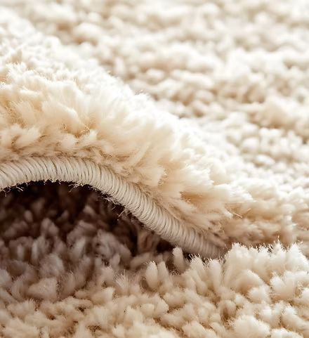 Close-up of a beige fluffy blanket with a visible seam and brown underside