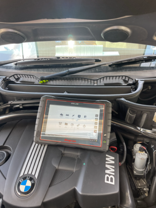 A Man Is Working On A Car With A Multimeter β Cabba Auto Electrics In Chinderah, NSW