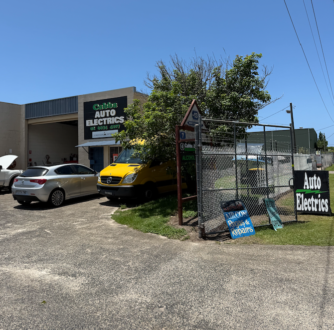 A Ute Next To A Car Both Parked In Front Of A Buildingβ Cabba Auto Electrics In Chinderah, NSW