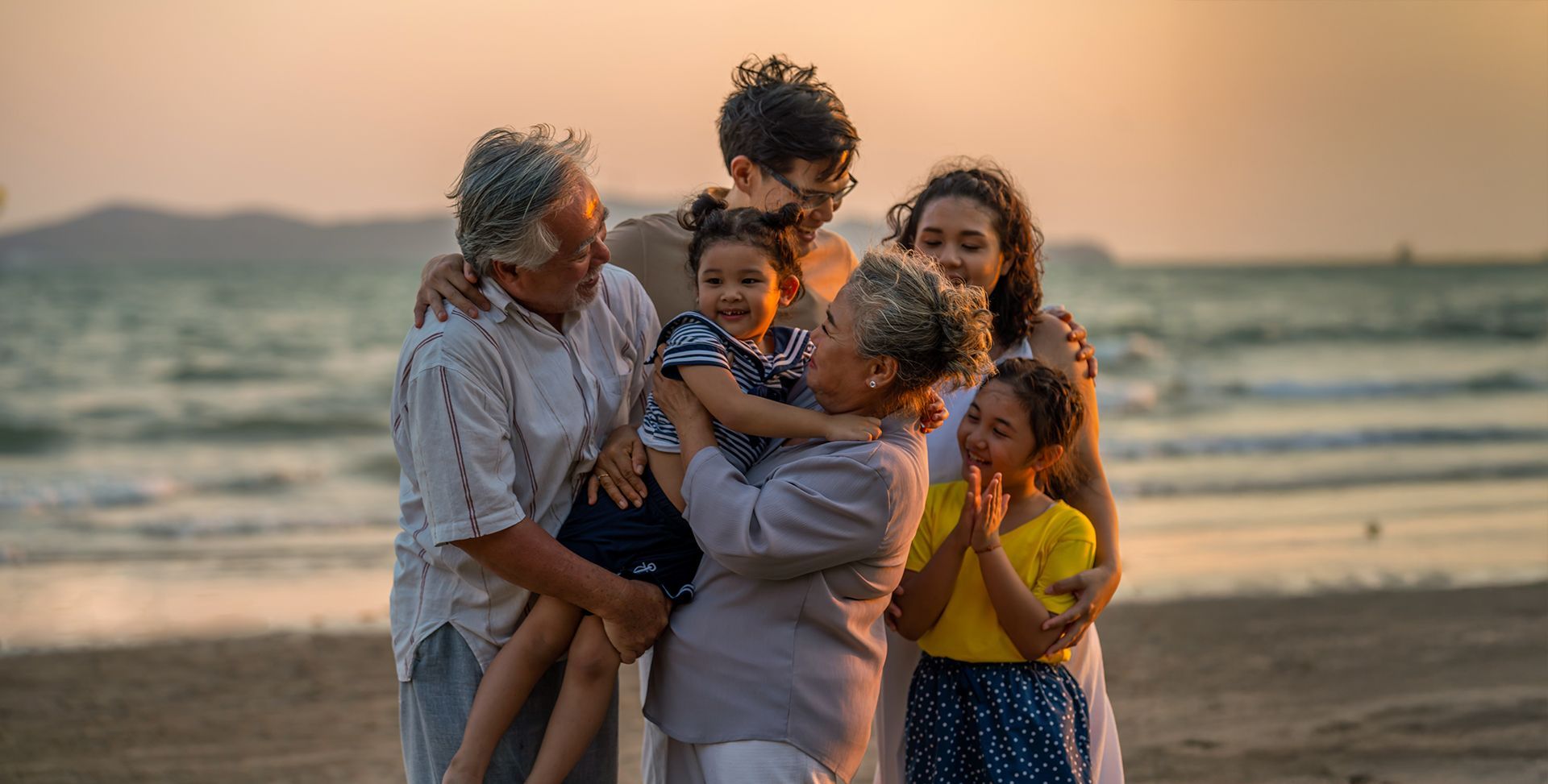 A family is posing for a picture on the beach.