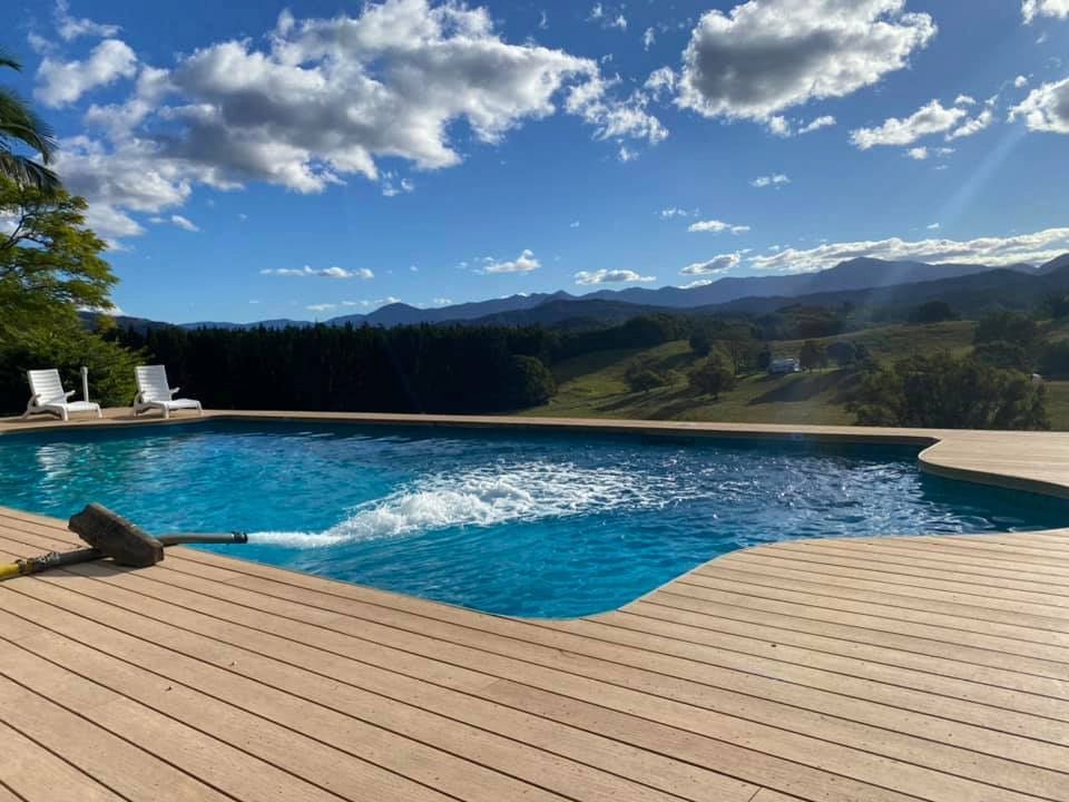 A Large Swimming Pool is Surrounded by a Wooden Deck — Jaiden Tanners Water Supplies in Murwillumbah, NSW