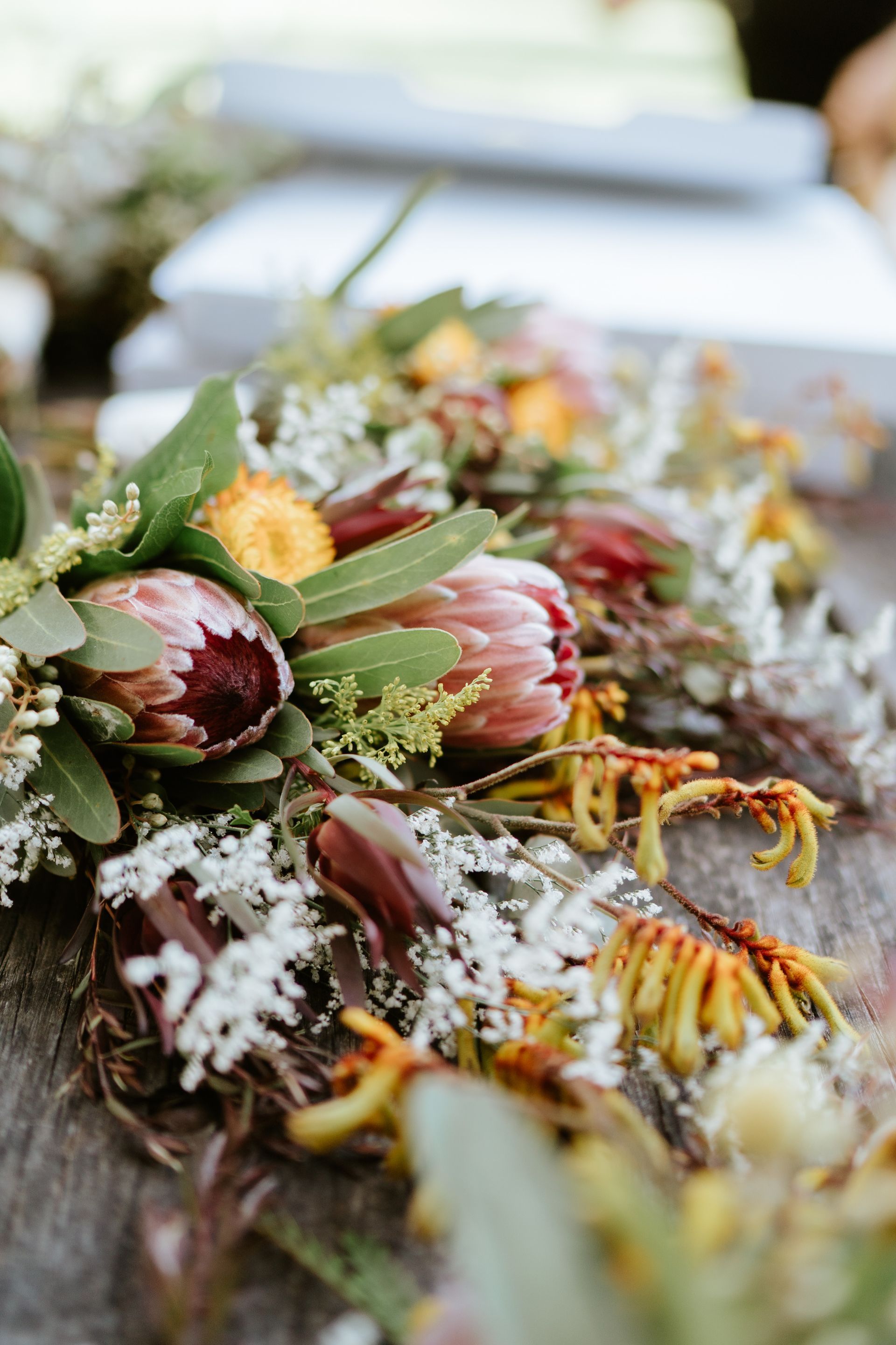 A colorful floral arrangement with green leaves and red, white, and yellow flowers on a table