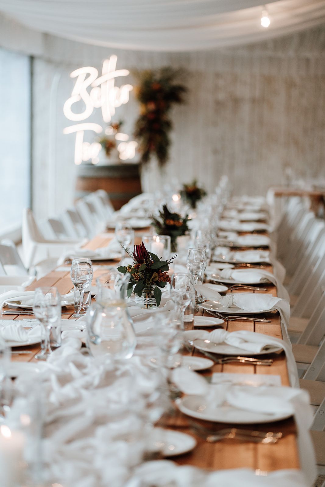 Elegant banquet table set for a formal event in a white-draped reception tent