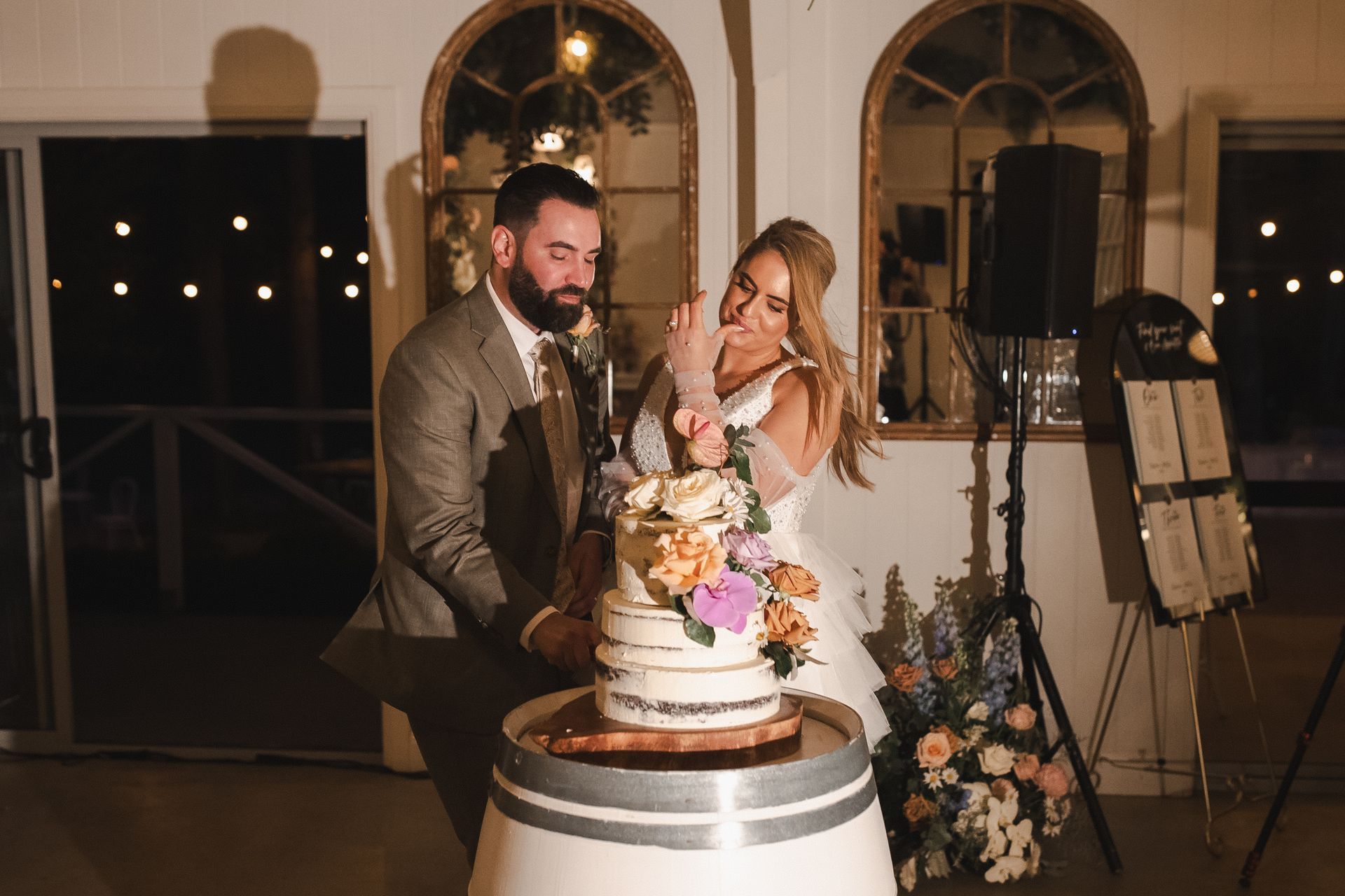 Bride and groom cutting a decorated wedding cake at an indoor reception