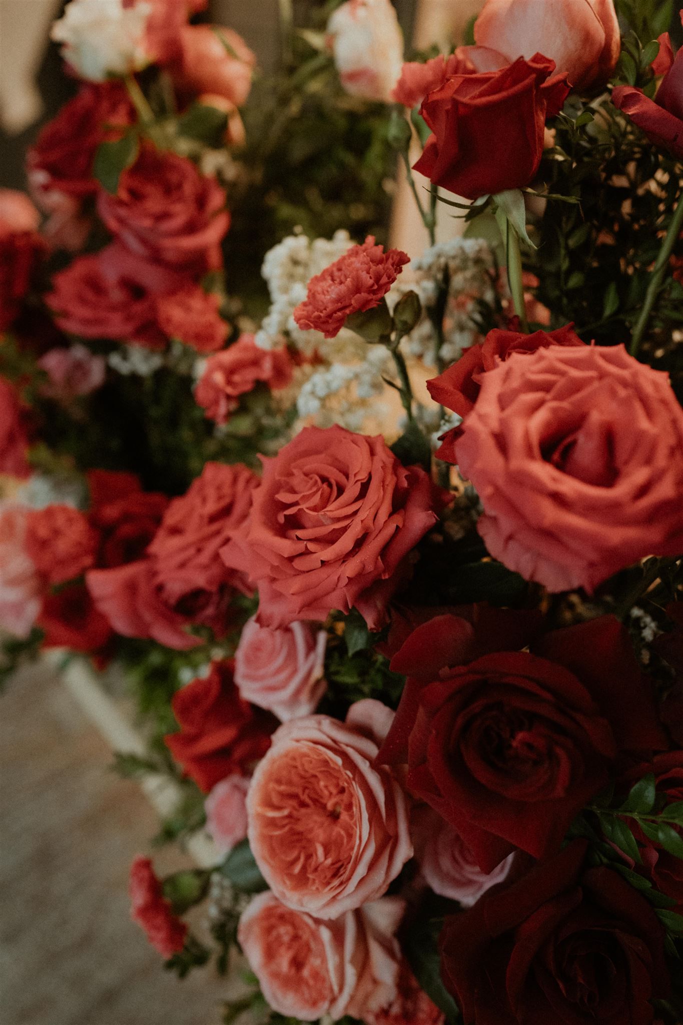Red and pink roses arranged in a lush floral bouquet