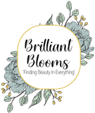 &ldquo;Brilliant Blooms&rdquo; floral logo with &ldquo;Finding Beauty in Everything&rdquo; on a white circle