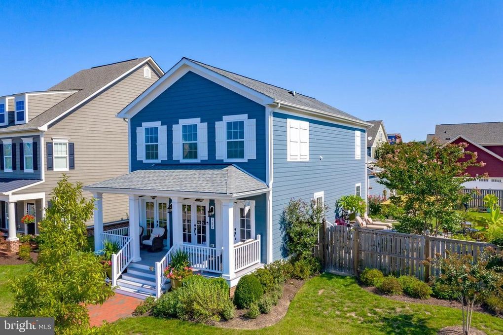 An aerial view of a blue and white house with a porch.