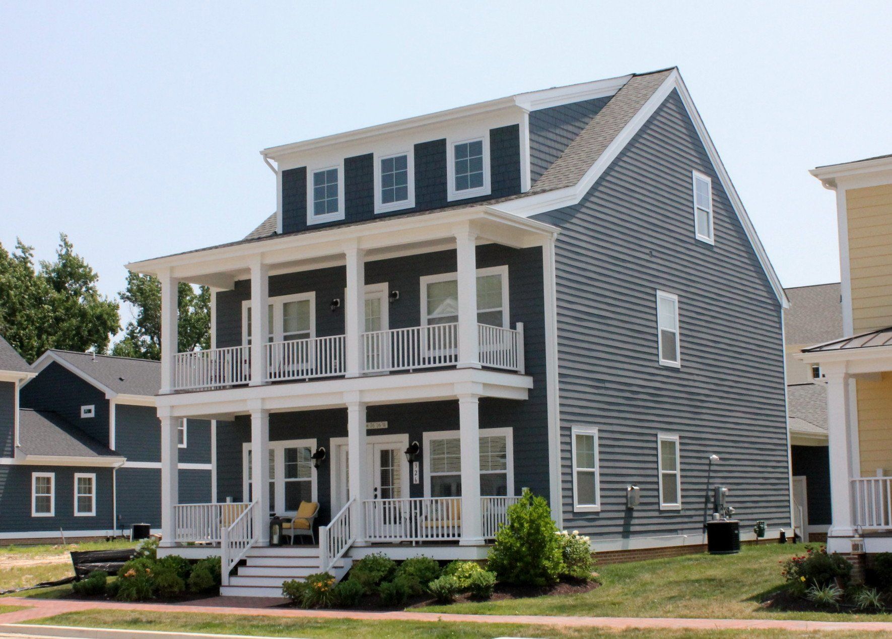 A large house with a large porch in a residential area
