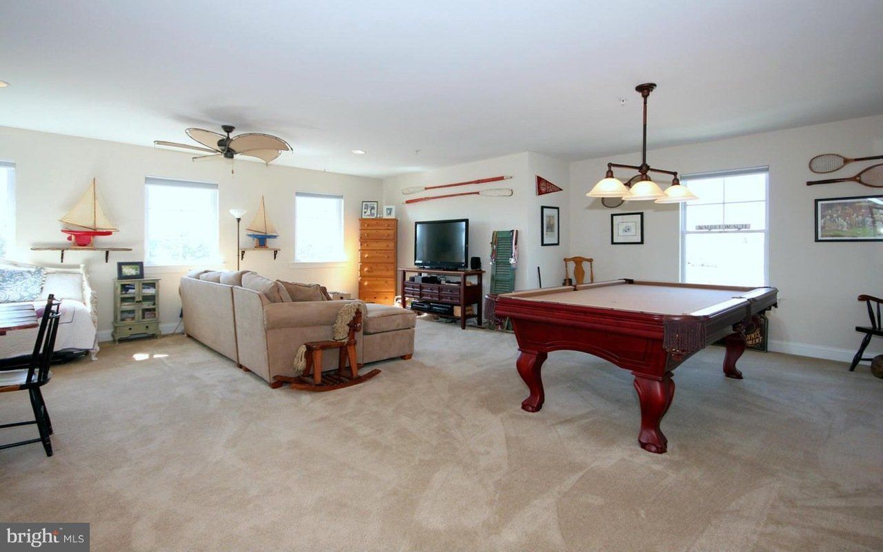 A living room with a pool table and a couch.