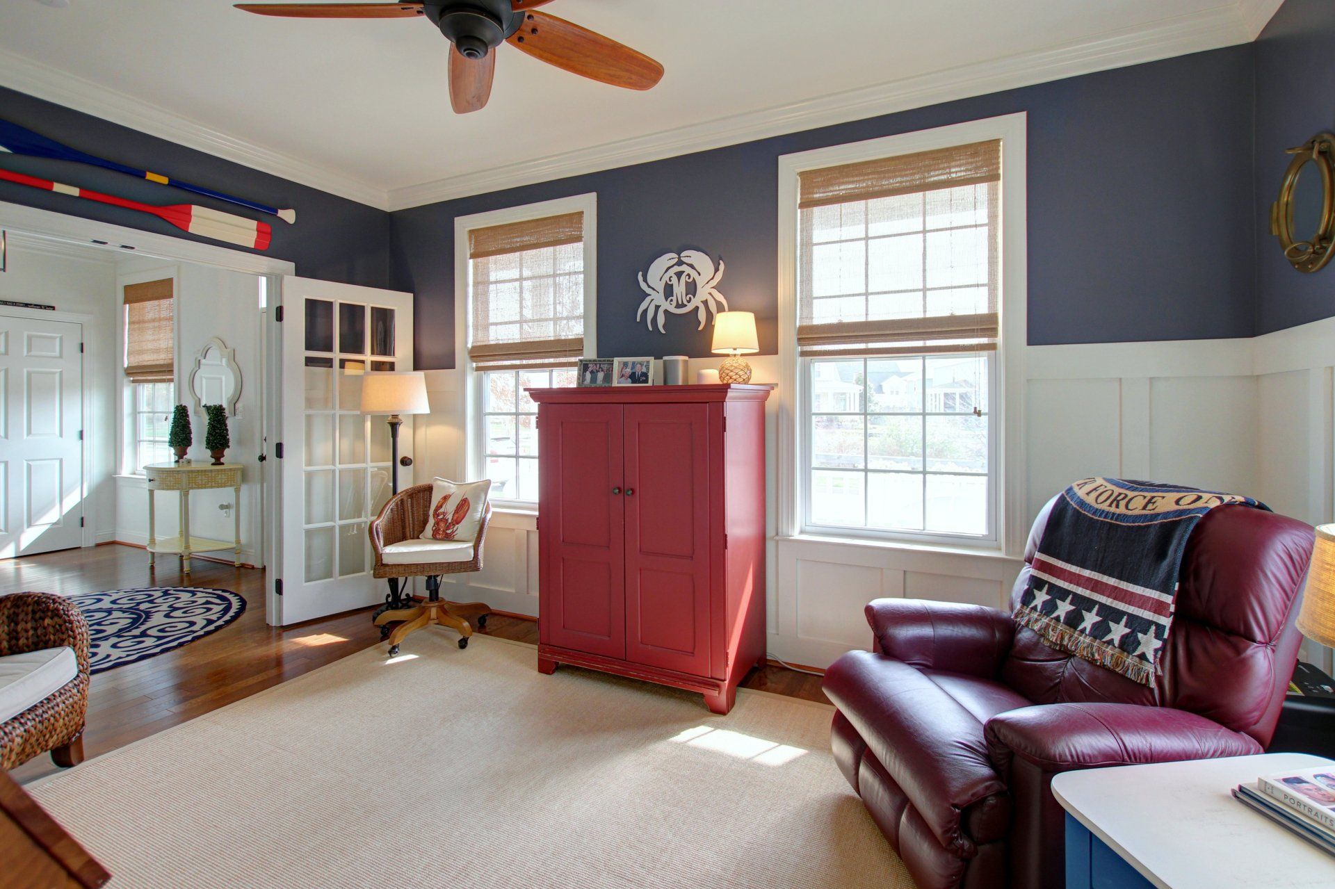 A living room with a ceiling fan and a red cabinet