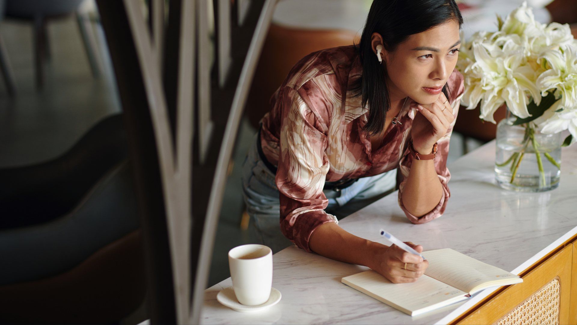 Woman deep in thought at desk working on preplanning her funeral arrangements