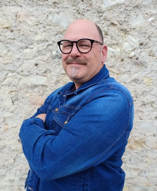 Een arbeider in een beige shirt en gereedschapsriem