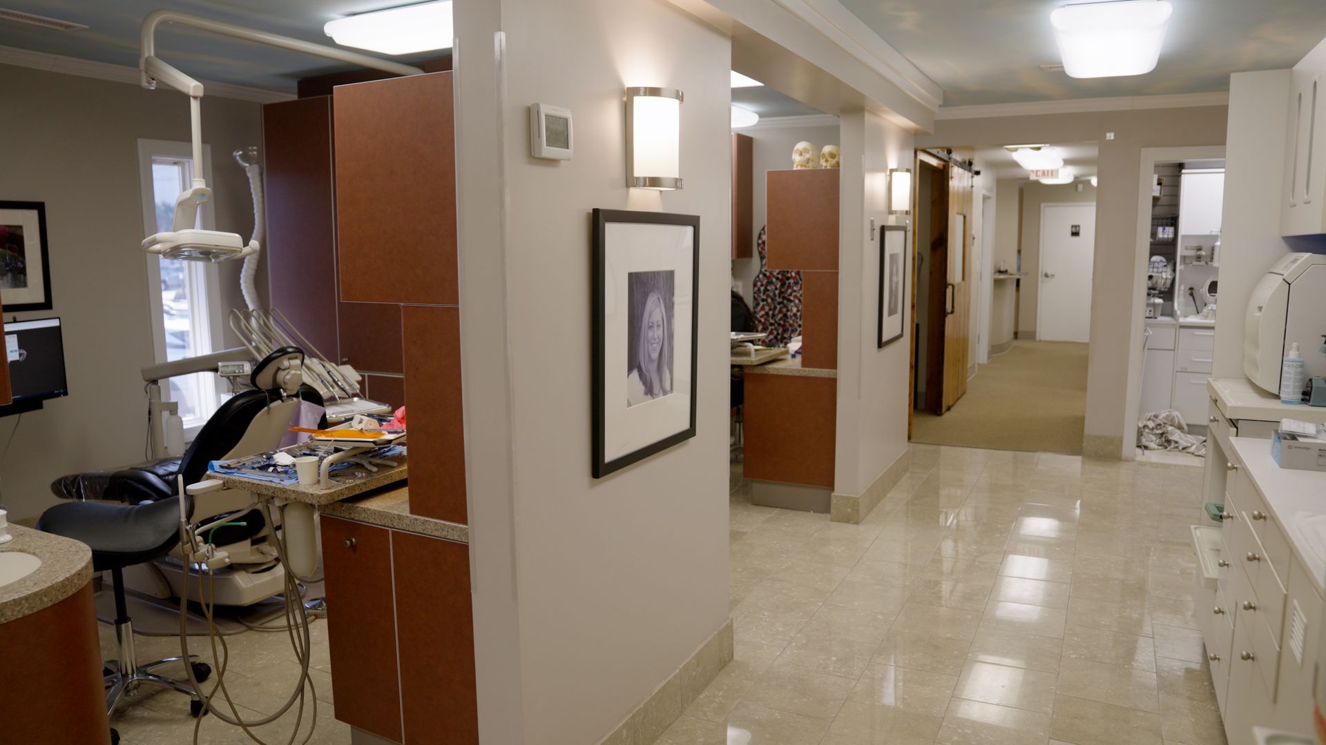 Dental hygienist in black scrubs and pink gloves treats a patient