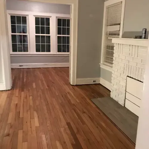 A living room with hardwood floors and a fireplace.