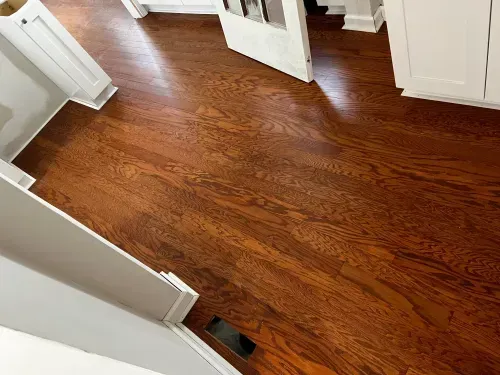 A kitchen with hardwood floors and white cabinets