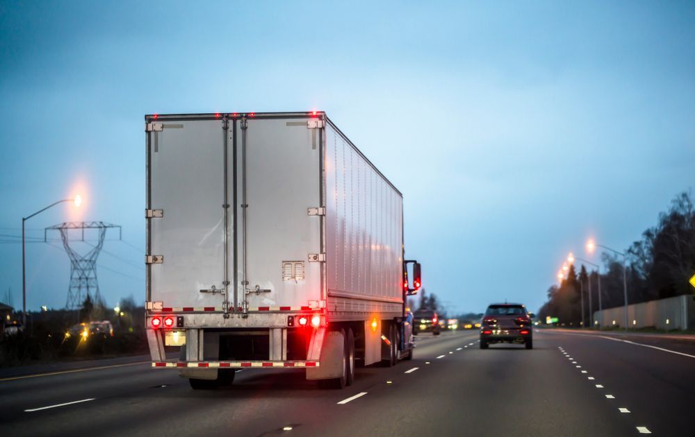 Semi-truck With Red Taillights Driving on a Highway at Dusk — Mission Truck Training in Gympie, QLD
