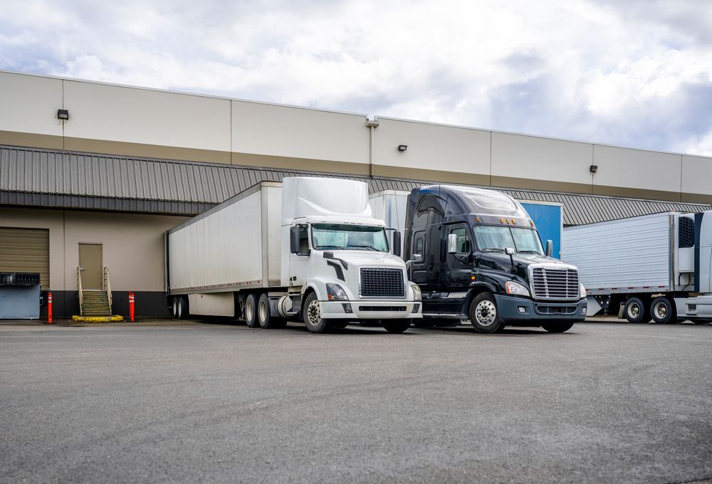 Semi-trucks Loading at a Warehouse Dock, Cloudy Sky Overhead — Mission Truck Training in Mountain Creek, QLD