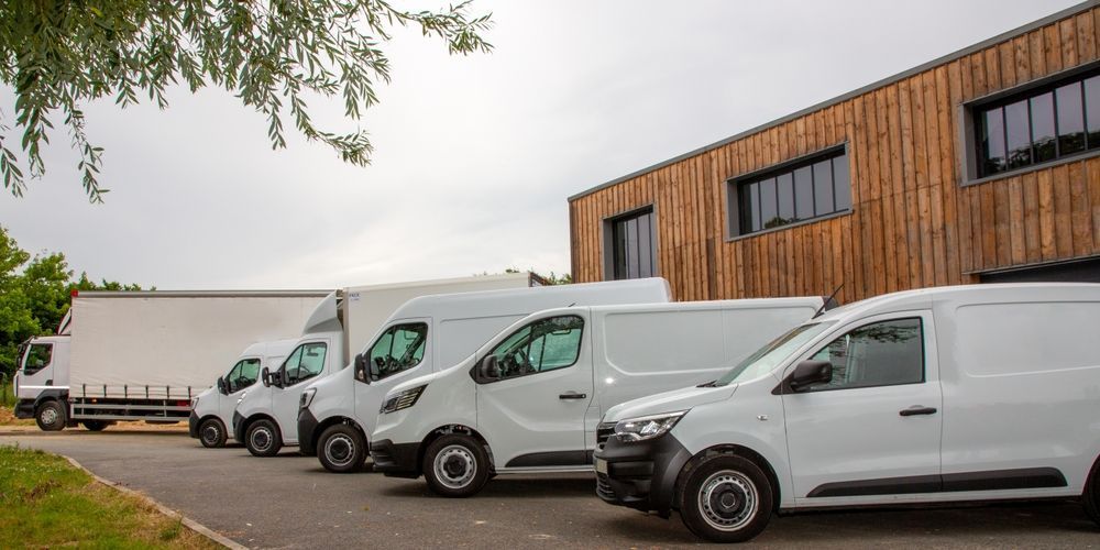 White Vans Parked in Front of a Wood-panelled Building With a Cloudy Sky — Mission Truck Training in Caboolture, QLD