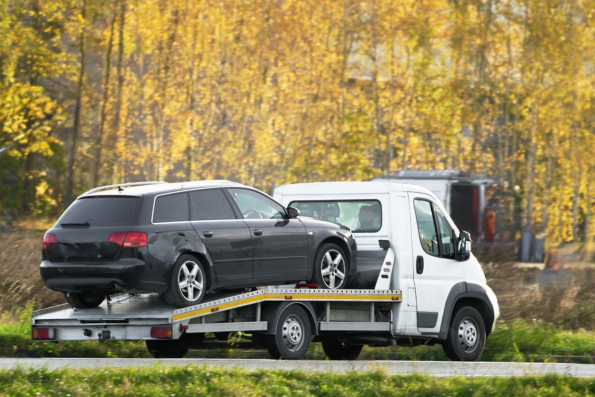 Dark Gray Car Loaded Onto a White Tow Truck on a Road — Mission Truck Training in Mountain Creek, QLD