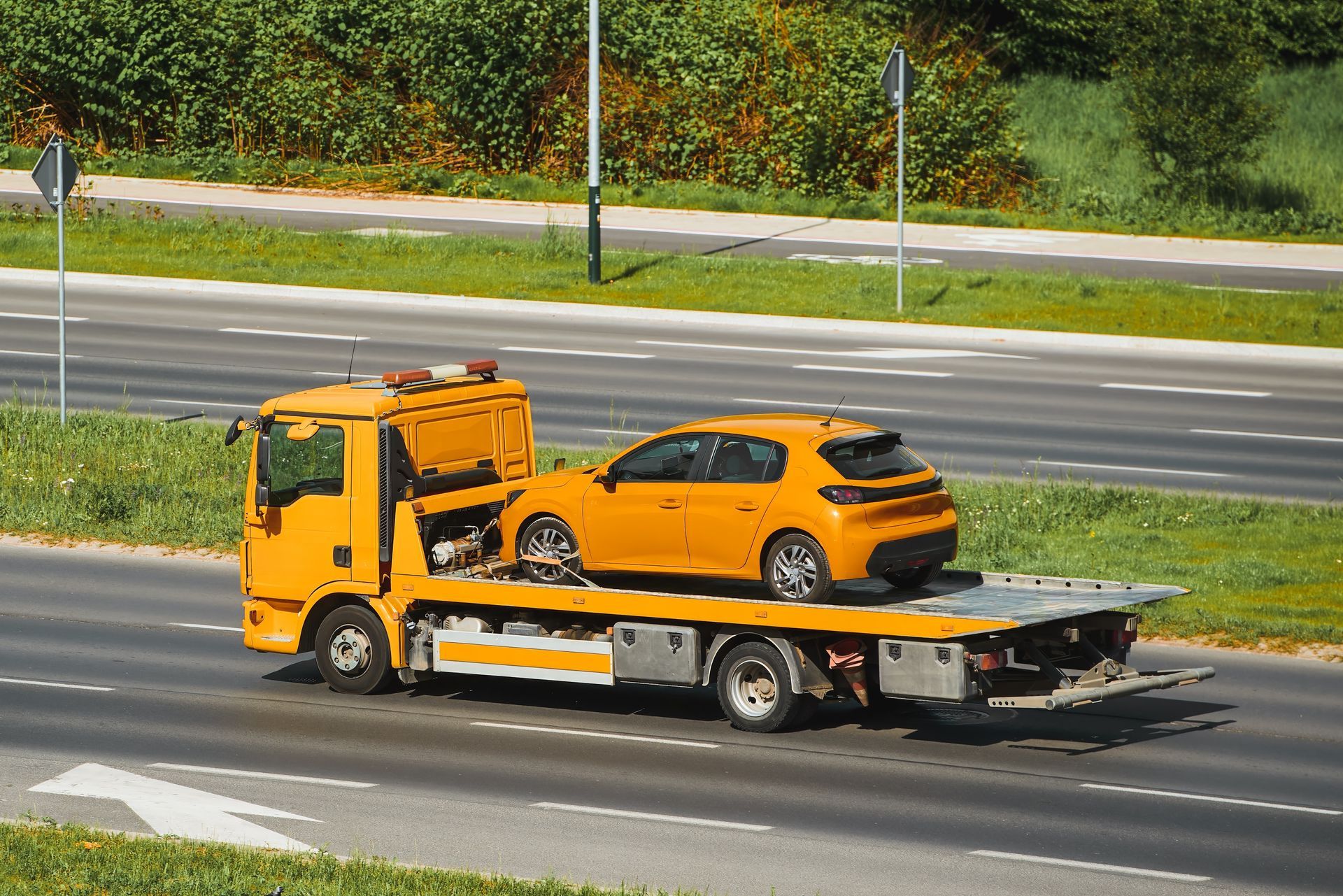Yellow Tow Truck Carrying a Matching Yellow Car on a Highway — Mission Truck Training in Fraser Coast, QLD