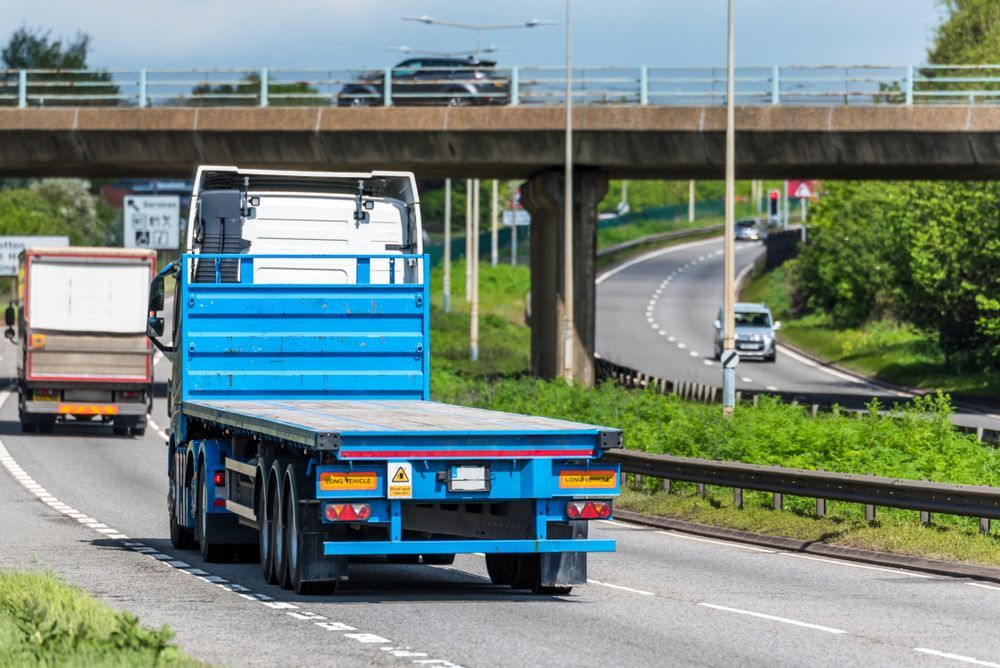 Flatbed Truck Driving on Highway, Under an Overpass Bridge — Mission Truck Training in Mountain Creek, QLD